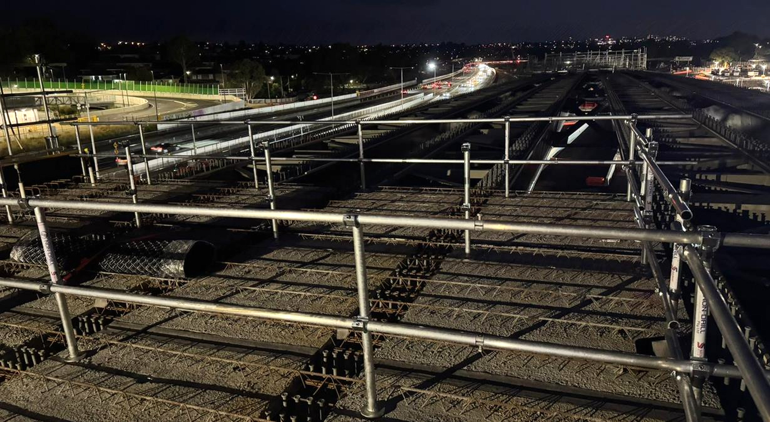 NON-DRILL edge protection installed along a bridge deck at night